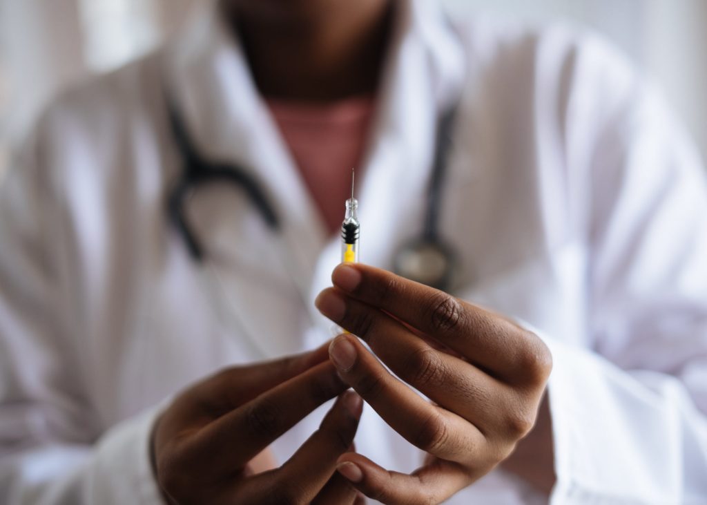 Everything You Need to Know About Flu Shots 2 a doctor holding a syringe