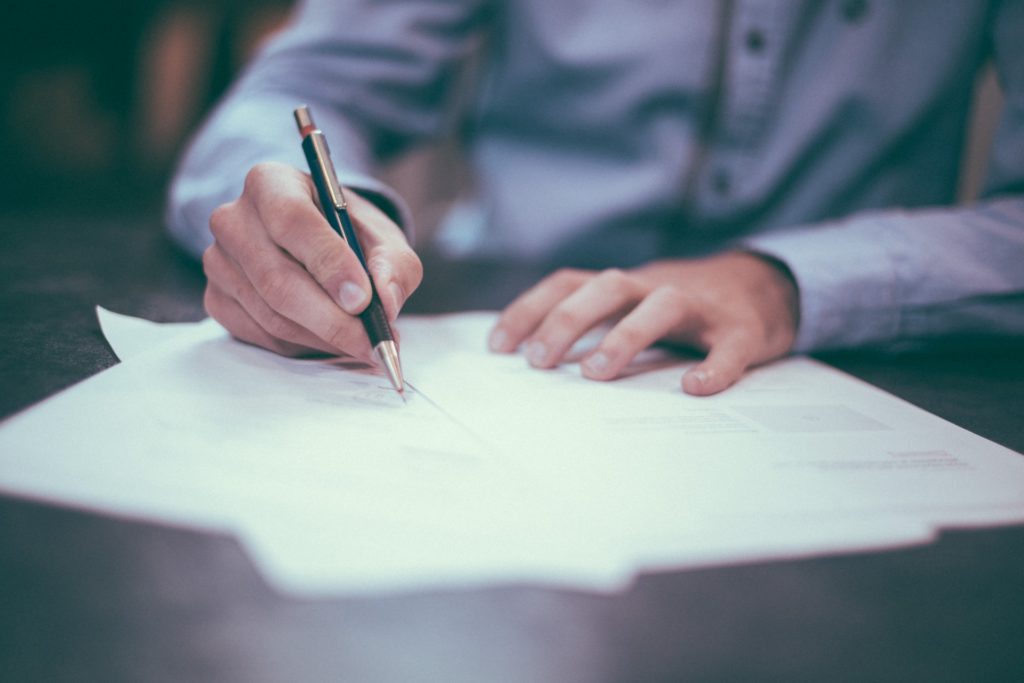 The Top 5 Reasons You Need Income Protection Insurance 3 a person writing on a piece of paper