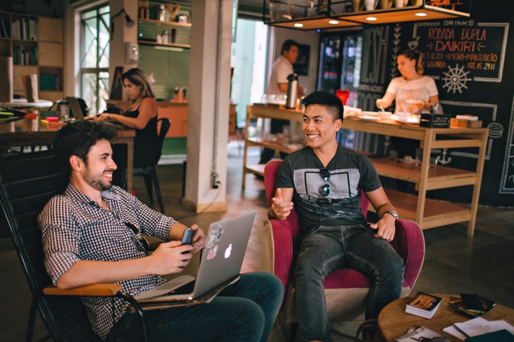 a group of people sitting in a room with laptops