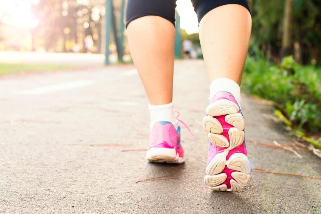 a person's legs in pink shoes