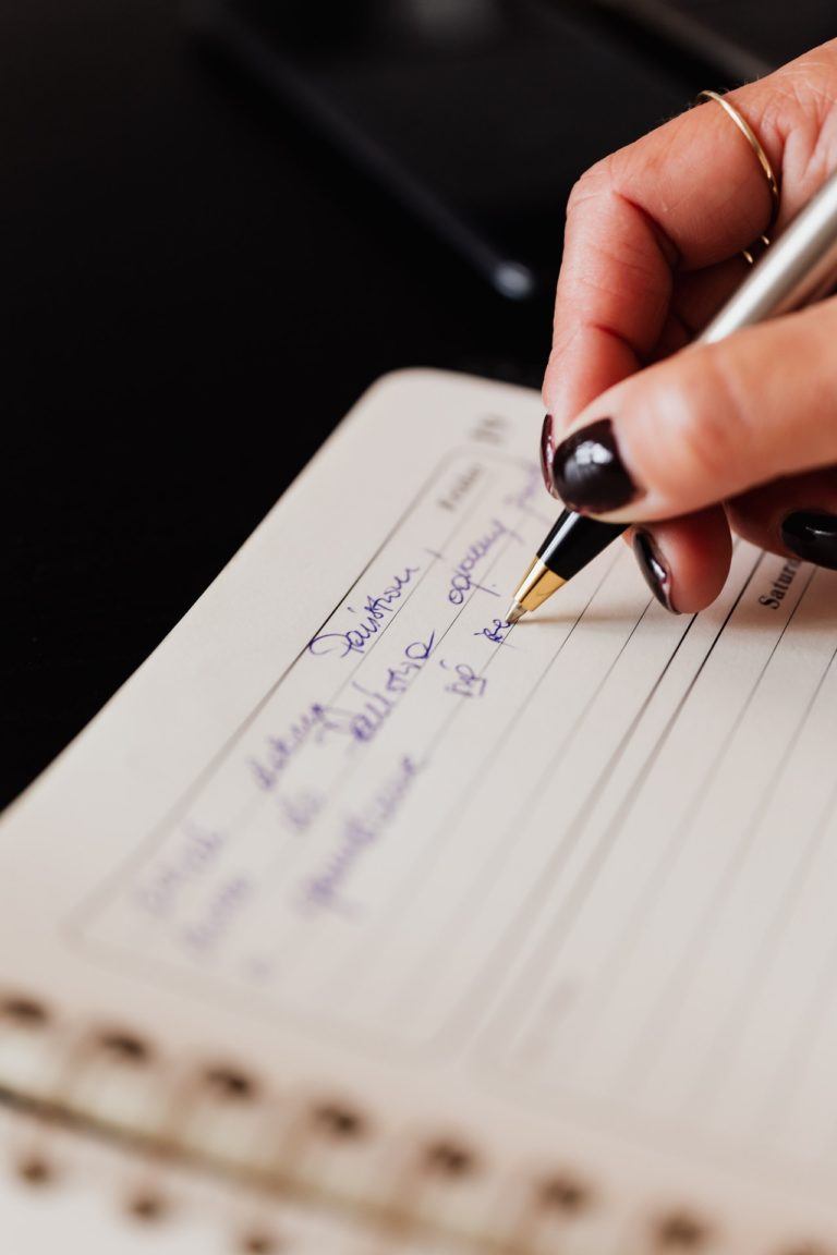 a hand holding a pen over a piece of paper