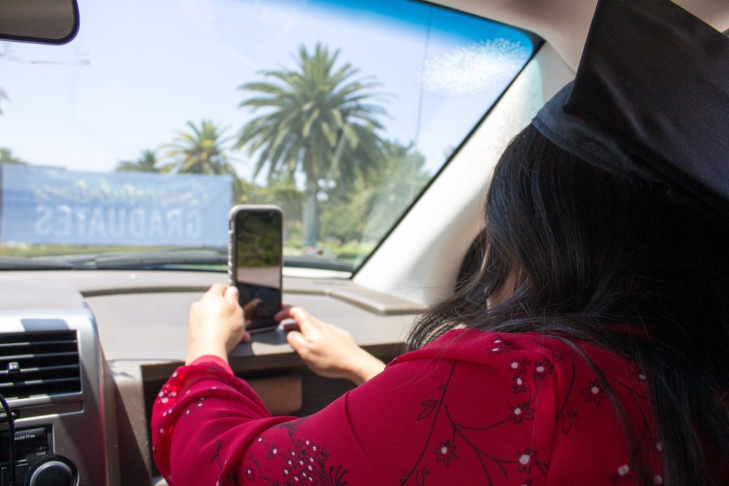 a woman taking a picture of a man in a car