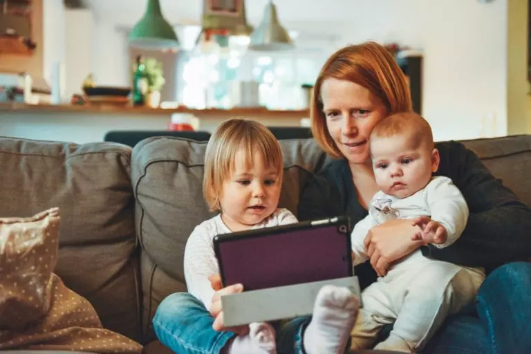 a person and a baby looking at a laptop