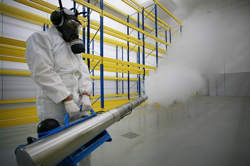 a man in a white suit in a factory