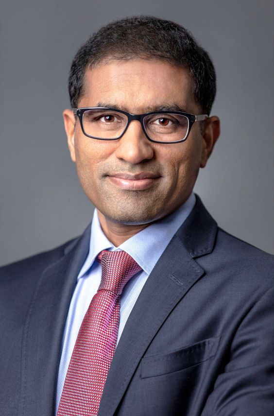 a man wearing glasses and a suit