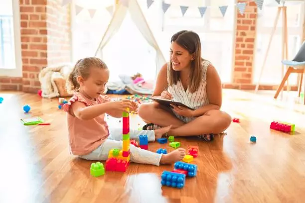 a person and a child playing with toys on the floor