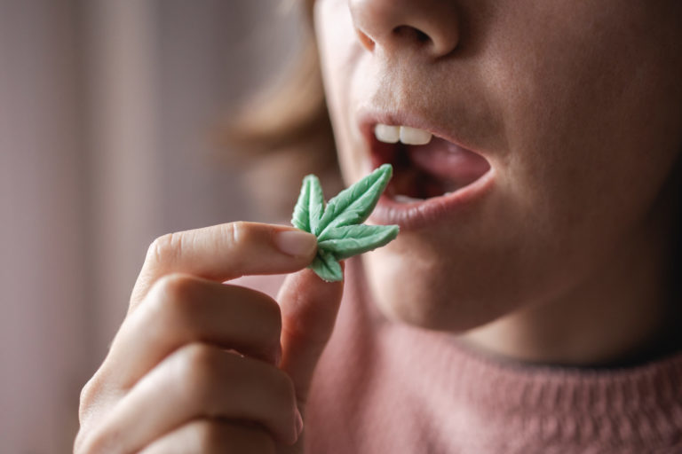 a woman eating a small green leaf